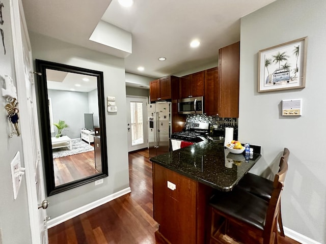 1366 W Greenleaf Ave Unit 3N, Chicago, IL 60626 - kitchen featuring stainless steel appliances, dark wood-style flooring, a peninsula, a breakfast bar area, and backsplash