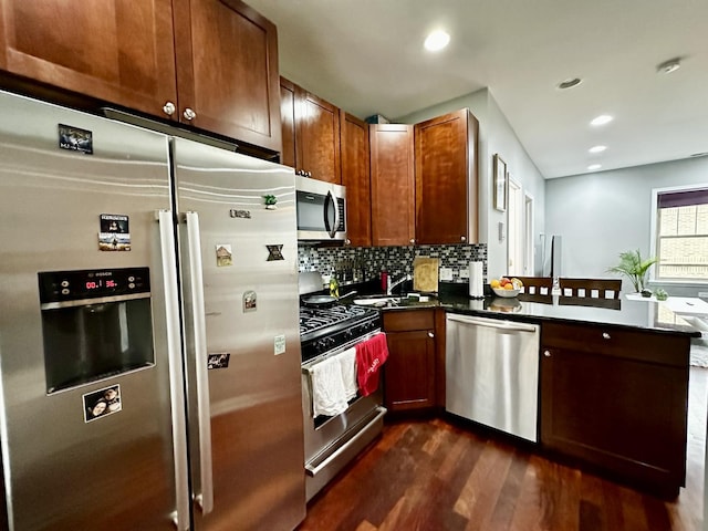 1366 W Greenleaf Ave Unit 3N, Chicago, IL 60626 - kitchen with stainless steel appliances, dark wood-type flooring, a peninsula, dark countertops, and tasteful backsplash