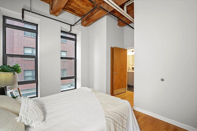 1503 S State St Unit 501, Chicago, IL 60605 - bedroom with wood finished floors, connected bathroom, and beam ceiling