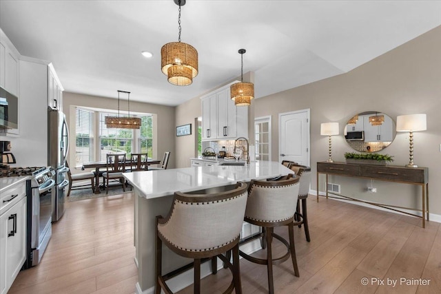 2213 Tyler Trl, Mchenry, IL 60051 - kitchen with gas stove, light wood-style flooring, white cabinets, a kitchen bar, and recessed lighting