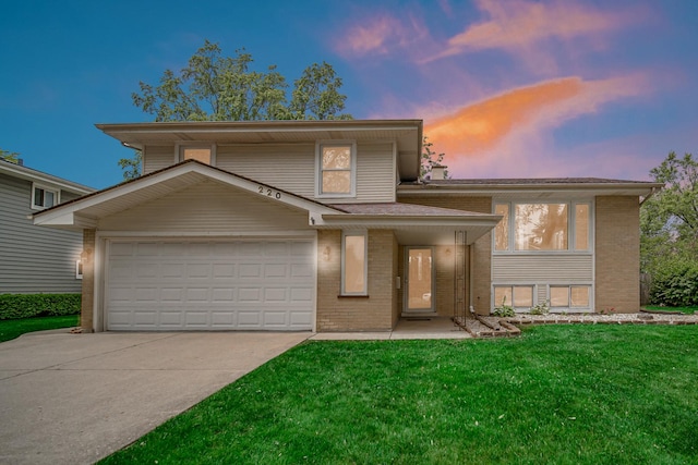 220 N Yates Ln, Mount Prospect, IL 60056 - tri-level home featuring brick siding, concrete driveway, a lawn, and a garage