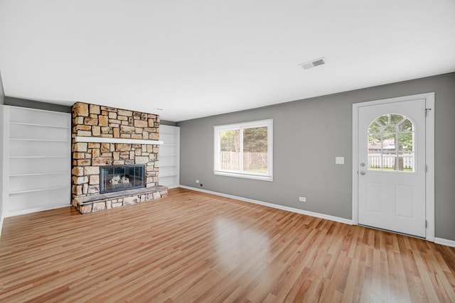 220 N Yates Ln, Mount Prospect, IL 60056 - unfurnished living room with plenty of natural light, light wood-type flooring, a fireplace, and built in shelves