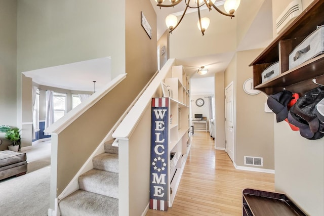 34113 N Primrose Ct, Round Lake, IL 60073 - stairway with a towering ceiling, a chandelier, and wood-type flooring