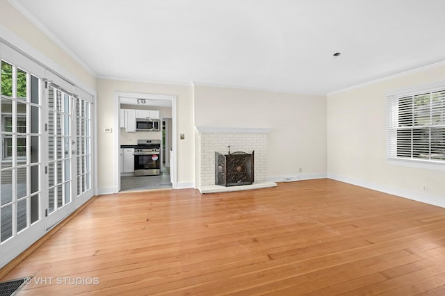 406 E Tower Dr, Tower Lakes, IL 60010 - unfurnished living room featuring ornamental molding, light wood finished floors, a fireplace, and healthy amount of natural light