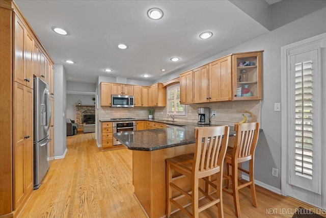 1009 E Bailey Rd, Naperville, IL 60565 - kitchen with appliances with stainless steel finishes, a peninsula, decorative backsplash, light wood-style floors, and recessed lighting
