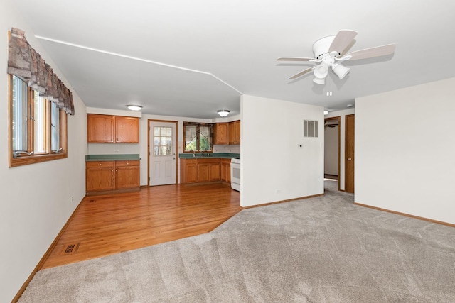 8928 S Ryan Rd, Hometown, IL 60456 - unfurnished living room with light colored carpet, a ceiling fan, and light wood finished floors