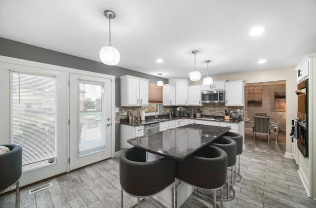 3105 Hermes Dr, Olympia Fields, IL 60461 - kitchen featuring appliances with stainless steel finishes, backsplash, light wood-style flooring, a center island, and a kitchen bar