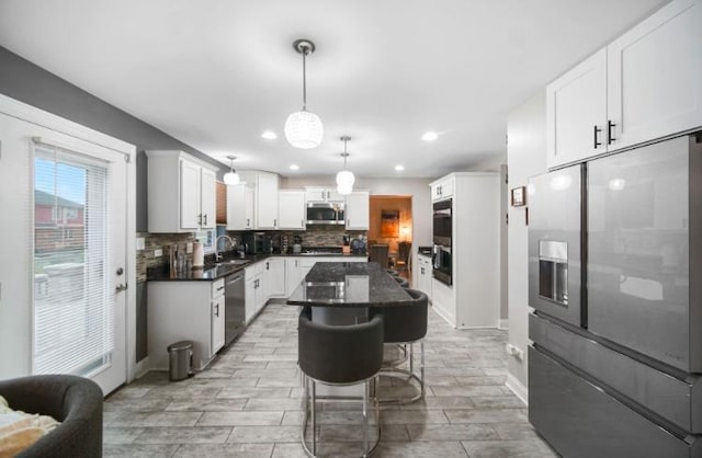 3105 Hermes Dr, Olympia Fields, IL 60461 - kitchen featuring appliances with stainless steel finishes, decorative backsplash, white cabinetry, a kitchen island, and a breakfast bar area