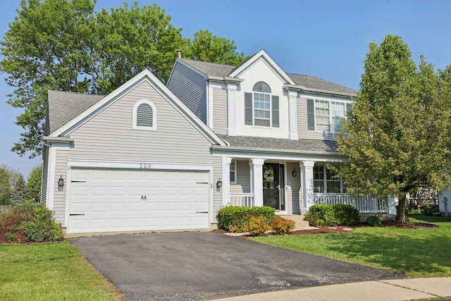 220 Carters Grove Ct, Grayslake, IL 60030 - traditional-style home with covered porch, asphalt driveway, a front lawn, and roof with shingles