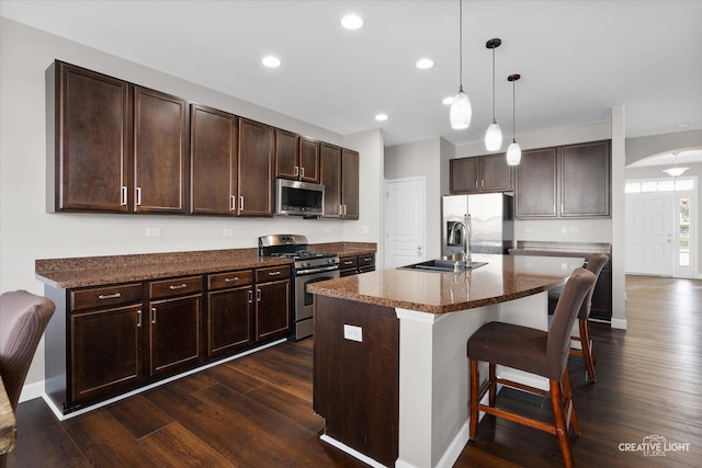 1133 Daytona Way, Pingree Grove, IL 60140 - kitchen with appliances with stainless steel finishes, arched walkways, a breakfast bar, dark brown cabinets, and recessed lighting