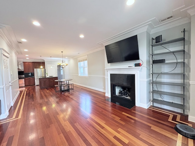 818 W Aldine Ave Unit 3, Chicago, IL 60657 - living area with dark wood finished floors, crown molding, a fireplace with flush hearth, recessed lighting, and a chandelier