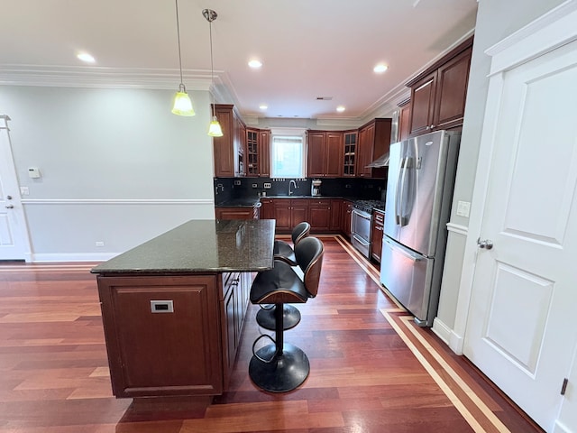 818 W Aldine Ave Unit 3, Chicago, IL 60657 - kitchen featuring appliances with stainless steel finishes, ornamental molding, a kitchen breakfast bar, a kitchen island, and glass insert cabinets