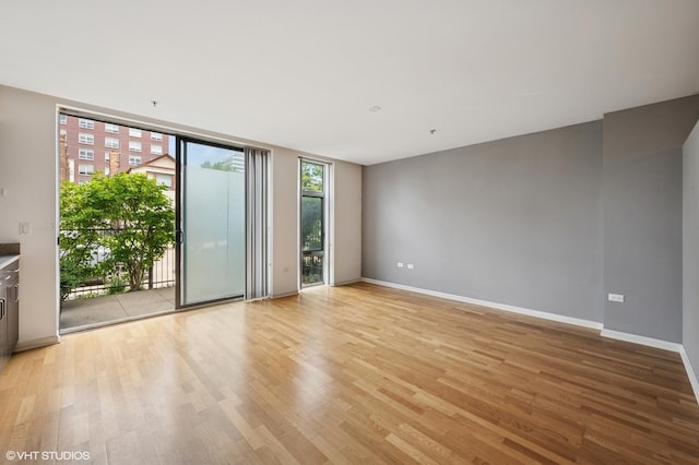 1740 Oak Ave Unit 103, Evanston, IL 60201 - spare room with floor to ceiling windows and light wood-style flooring