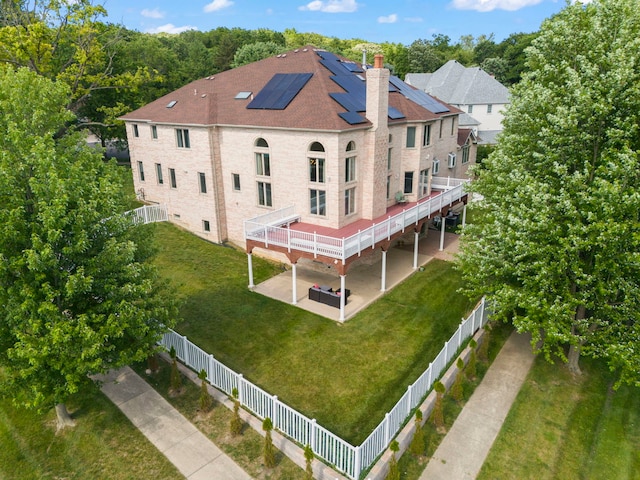 2308 Fleetwood Ct, Naperville, IL 60565 - rear view of house with roof mounted solar panels, a fenced backyard, a chimney, brick siding, and a patio area