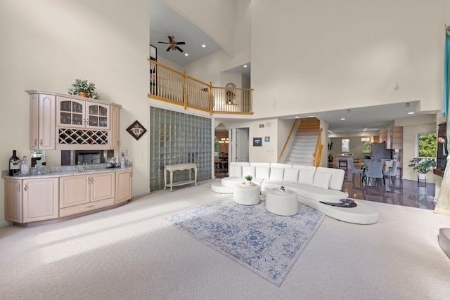 2308 Fleetwood Ct, Naperville, IL 60565 - living room featuring a towering ceiling, stairs, a ceiling fan, light carpet, and arched walkways