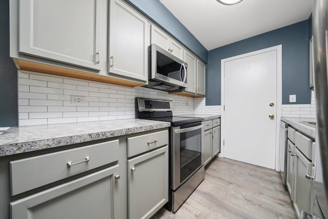 5701 W 129th St Unit 2B, Crestwood, IL 60418 - kitchen featuring stainless steel appliances, gray cabinets, light wood finished floors, light countertops, and tasteful backsplash