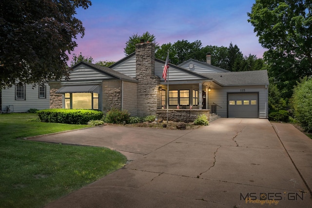 115 Fair St, Sycamore, IL 60178 - view of front of house with an attached garage, a lawn, a chimney, driveway, and stone siding