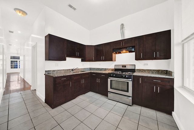 2638 W Adams St, Chicago, IL 60612 - kitchen featuring gas stove, under cabinet range hood, light tile patterned floors, and light stone countertops