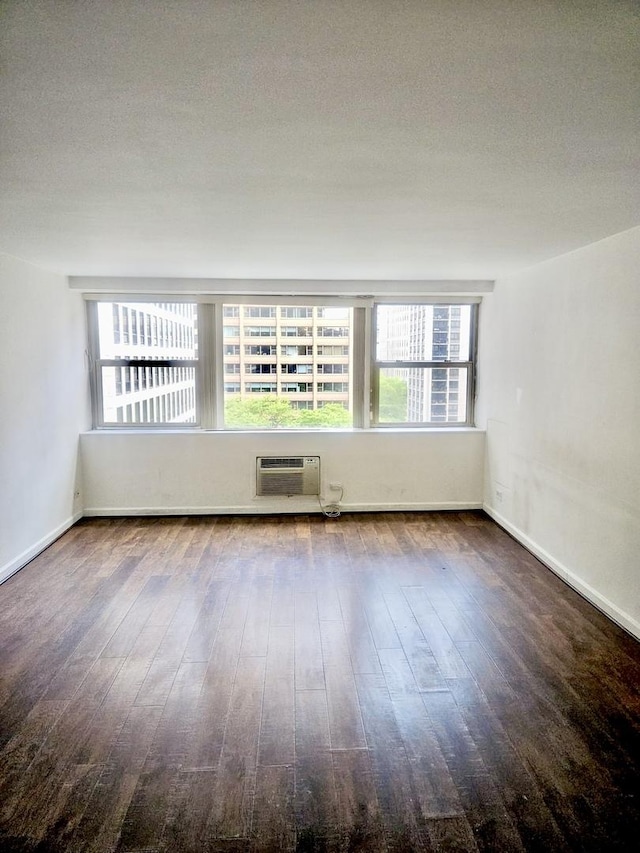 253 E Delaware Pl Unit 8F, Chicago, IL 60611 - spare room featuring an AC wall unit and hardwood / wood-style floors