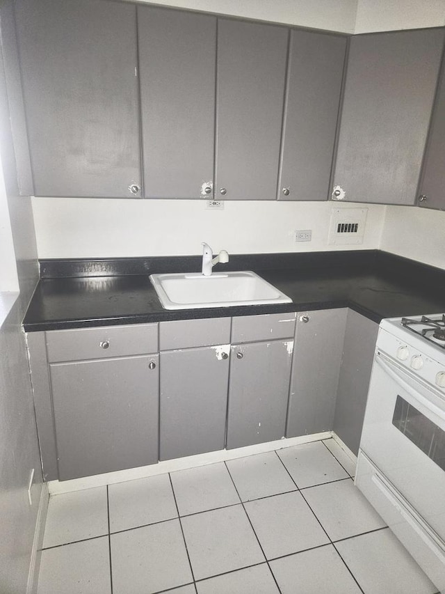 253 E Delaware Pl Unit 8F, Chicago, IL 60611 - kitchen with gray cabinets, dark countertops, white range oven, and light tile patterned floors