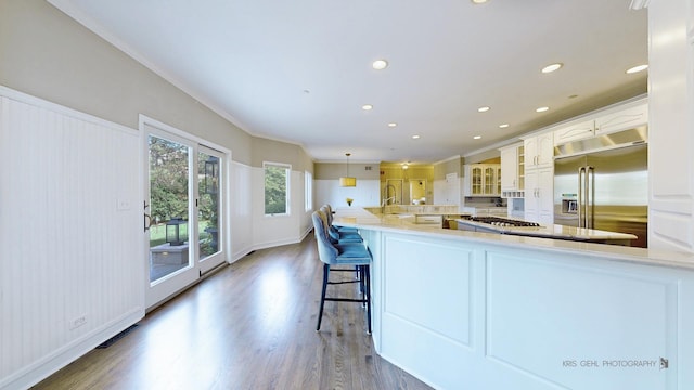 2520 Hanford Ln, Aurora, IL 60502 - kitchen featuring stainless steel appliances, wood finished floors, glass insert cabinets, recessed lighting, and white cabinetry