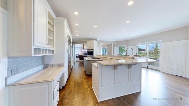 2520 Hanford Ln, Aurora, IL 60502 - kitchen with tasteful backsplash, dark wood-type flooring, a kitchen breakfast bar, white cabinetry, and crown molding