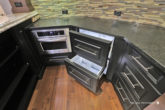 2520 Hanford Ln, Aurora, IL 60502 - kitchen featuring stainless steel oven, decorative backsplash, dark wood-style flooring, and dark countertops
