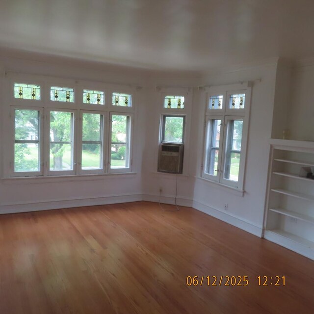 7741 S Indiana Ave, Chicago, IL 60619 - unfurnished living room featuring cooling unit, light wood-style flooring, and plenty of natural light