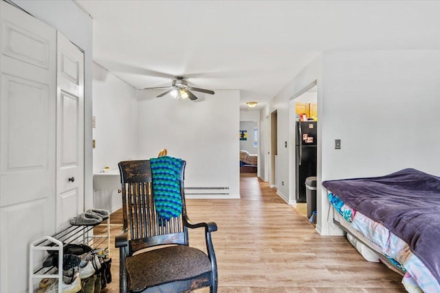 413 Berkshire Dr Unit 22, Crystal Lake, IL 60014 - bedroom featuring freestanding refrigerator, light wood-style flooring, a baseboard radiator, and a ceiling fan