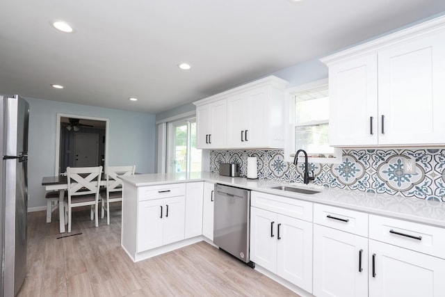 620 Edwin Dr, Bourbonnais, IL 60914 - kitchen with stainless steel appliances, backsplash, light countertops, a peninsula, and white cabinetry