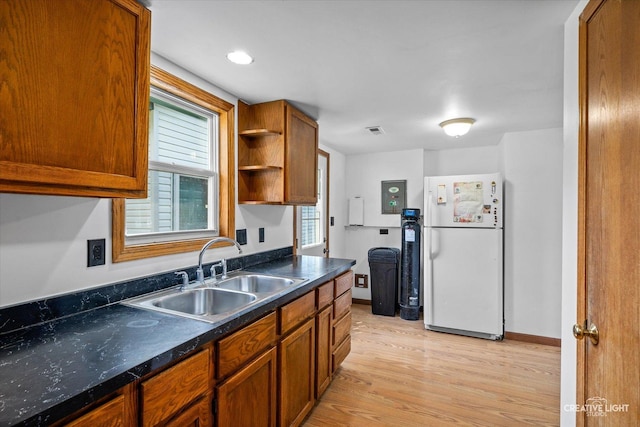 812 S Sumner Ave, Aurora, IL 60505 - kitchen with freestanding refrigerator, light wood finished floors, brown cabinets, dark countertops, and open shelves