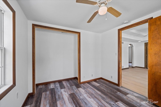 812 S Sumner Ave, Aurora, IL 60505 - unfurnished bedroom with dark wood finished floors, arched walkways, a tray ceiling, ceiling fan, and a closet