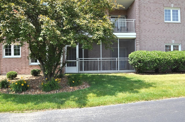 11535 Settlers Pond Way Unit 1C, Orland Park, IL 60467 - view of property exterior featuring brick siding, a yard, a balcony, and a sunroom