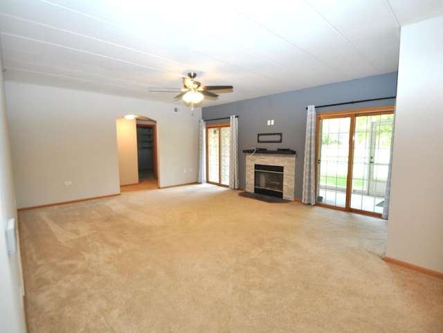 11535 Settlers Pond Way Unit 1C, Orland Park, IL 60467 - unfurnished living room featuring light carpet, a fireplace with raised hearth, a ceiling fan, and arched walkways