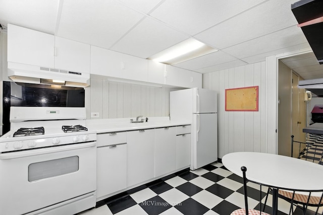 3219 N Pioneer Ave, Chicago, IL 60634 - kitchen featuring white appliances, under cabinet range hood, dark floors, light countertops, and white cabinets