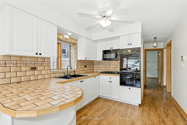 3219 N Pioneer Ave, Chicago, IL 60634 - kitchen featuring black appliances, light wood-style flooring, backsplash, white cabinetry, and a ceiling fan