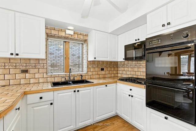 3219 N Pioneer Ave, Chicago, IL 60634 - kitchen featuring black appliances, tile countertops, and white cabinetry