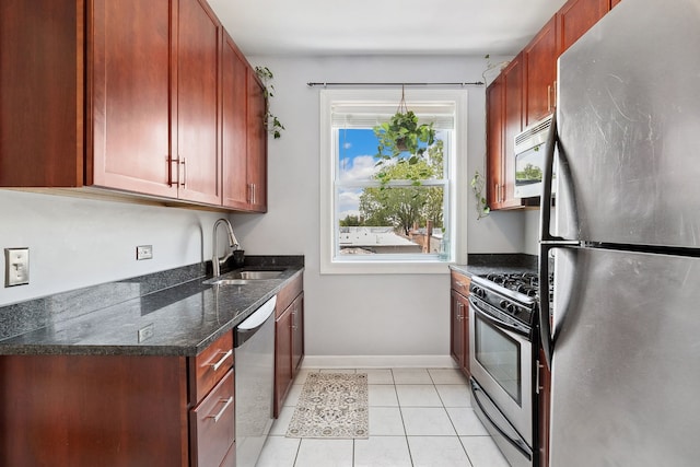 2438 N Hamlin Ave Unit 3D, Chicago, IL 60647 - kitchen featuring stainless steel appliances, light tile patterned flooring, dark stone countertops, and dark brown cabinets