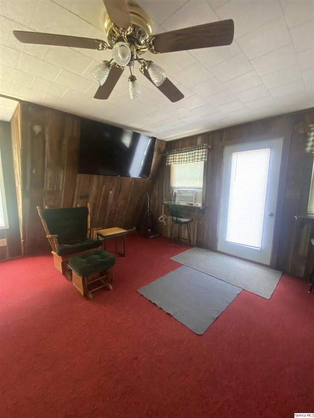 110 E County Rd 150, Warsaw, IL 62379 - living area featuring carpet, wood walls, a ceiling fan, and cooling unit