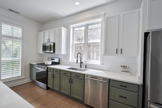 1501 W Diversey Pkwy Unit B, Chicago, IL 60614 - kitchen featuring appliances with stainless steel finishes, tasteful backsplash, light wood-style flooring, and light countertops