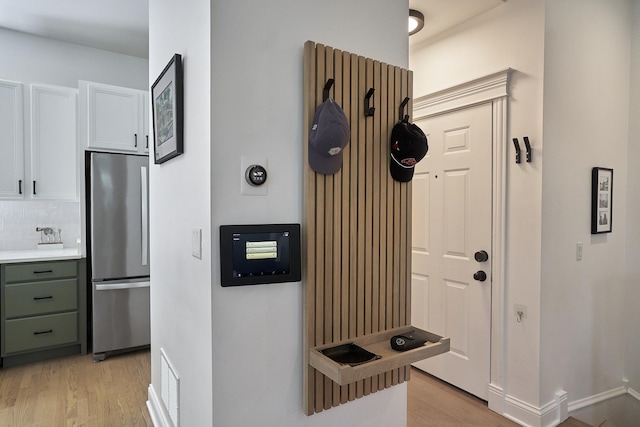 1501 W Diversey Pkwy Unit B, Chicago, IL 60614 - kitchen featuring freestanding refrigerator, light wood-style floors, white cabinetry, decorative backsplash, and light countertops
