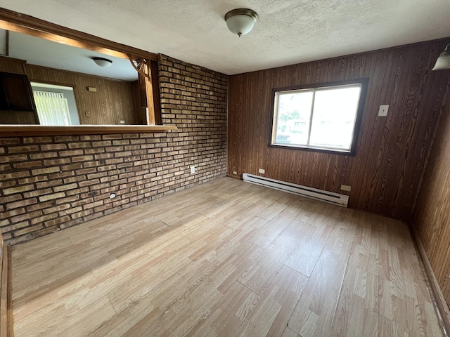 327 Somonauk St, Park Forest, IL 60466 - unfurnished room featuring a baseboard radiator, wood finished floors, a textured ceiling, wooden walls, and brick wall