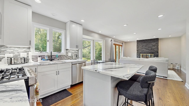 3425 Woodlawn Ave, Gurnee, IL 60031 - kitchen with stainless steel appliances, light wood-type flooring, backsplash, light stone countertops, and recessed lighting