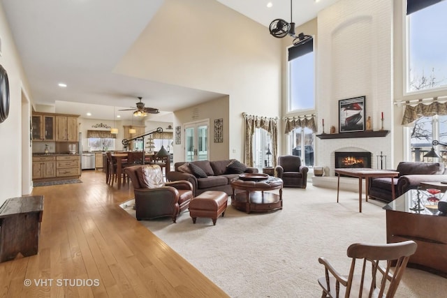 49W695 Hinckley Rd, Big Rock, IL 60511 - living room featuring a towering ceiling, a brick fireplace, ceiling fan, light wood-style flooring, and recessed lighting