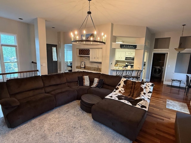 1779 Frost Ln, Naperville, IL 60564 - living room featuring washer / dryer, a chandelier, wood finished floors, and a towering ceiling