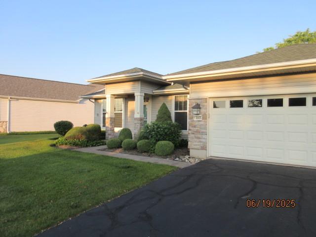 13005 Big Horn Dr, Huntley, IL 60142 - view of front of house featuring driveway, a front lawn, a garage, and stone siding