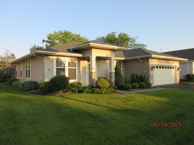 13005 Big Horn Dr, Huntley, IL 60142 - view of front of house featuring driveway, a front lawn, a garage, and stone siding
