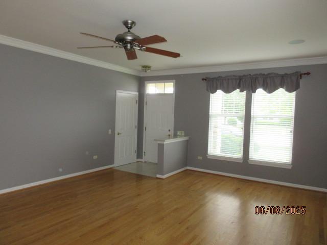 13005 Big Horn Dr, Huntley, IL 60142 - empty room featuring wood finished floors, a ceiling fan, and crown molding