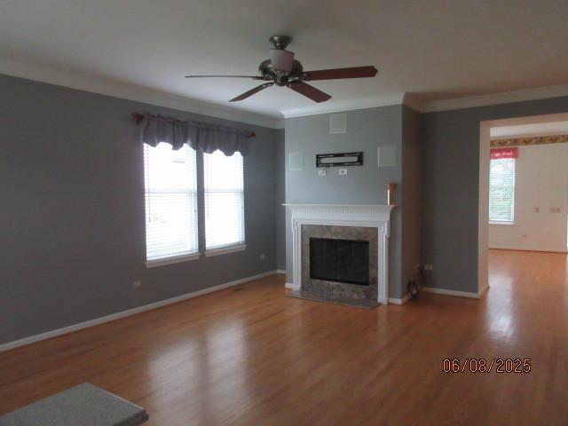 13005 Big Horn Dr, Huntley, IL 60142 - unfurnished living room featuring ornamental molding, wood finished floors, a fireplace, and ceiling fan