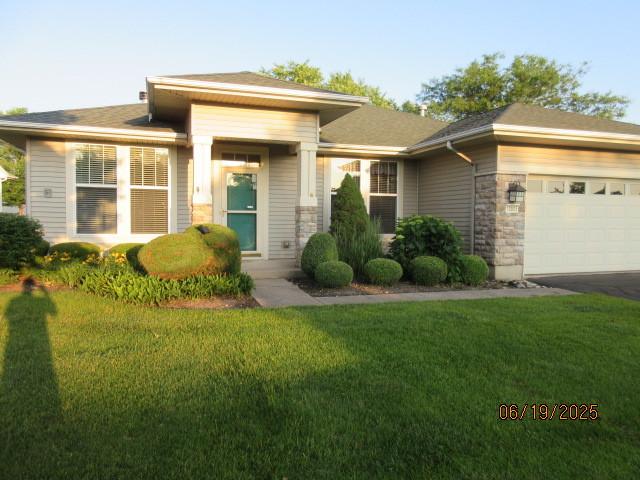 13005 Big Horn Dr, Huntley, IL 60142 - prairie-style home with a front lawn, an attached garage, stone siding, and driveway